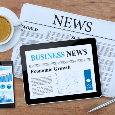 News paper, tablet, coffee on table.